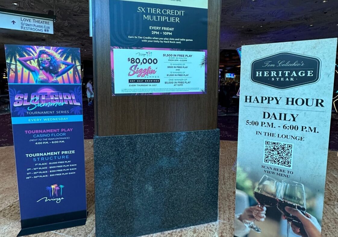 Three promotional signs advertising events and happy hour specials at a bar.